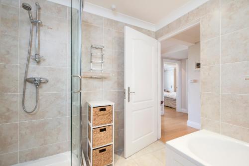 Un baño con ducha con puerta de cristal en James Braid Suite, en Newport