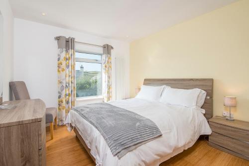 Un dormitorio con una cama grande y una ventana. en 6 Wood Village, en Haverfordwest