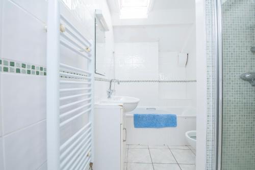 Un baño blanco con lavabo e inodoro. en The Nook, en Manorbier