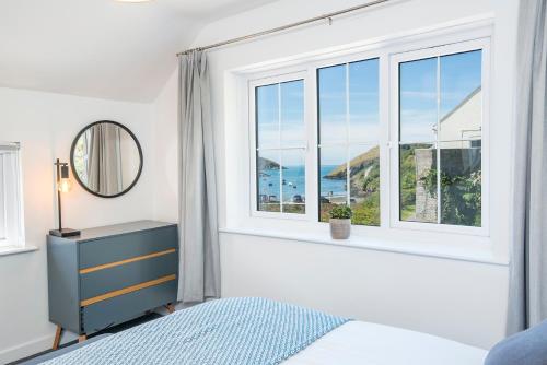 ein Schlafzimmer mit einem Fenster mit Blick auf das Meer in der Unterkunft Ty Olwen in Haverfordwest