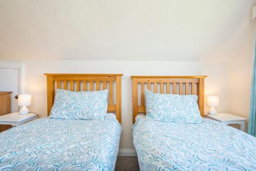 two beds sitting next to each other in a bedroom at Cnwc Y Wylan in Cardigan