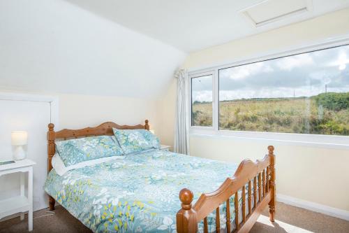 a bedroom with a bed and a large window at Cnwc Y Wylan in Cardigan