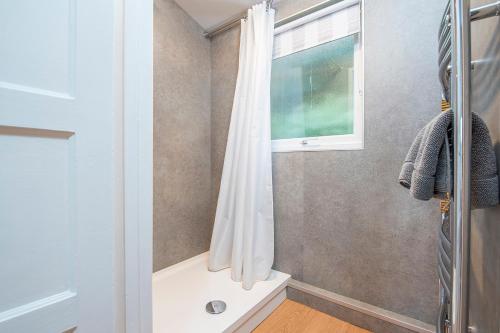 Un baño con ducha y ventana. en Valley View, en Haverfordwest