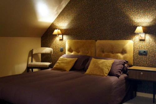 ein Schlafzimmer mit einem großen Bett und einem Stuhl in der Unterkunft La Lanterne in Corps-Nuds