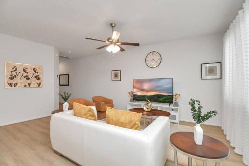 a living room with a white couch and a clock on the wall at Exquisite Relocation and Workers Dream Place in Katy