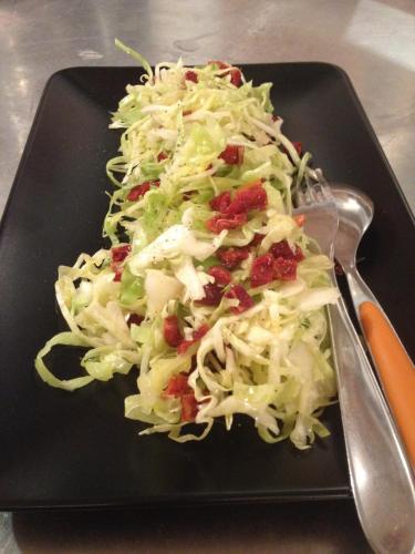 a black plate with a salad on a table at Agriturismo Albero del Latte in Bagnolo San Vito