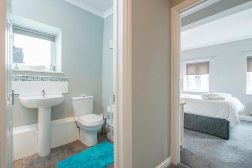 ein Badezimmer mit Waschbecken und Toilette und ein Bett in der Unterkunft Inkerman House in Saundersfoot