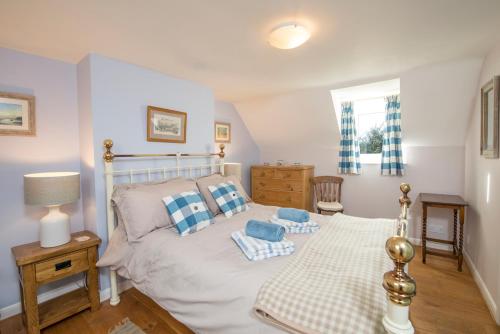 a bedroom with a bed with blue and white pillows at Drws Gobaith-West in Haverfordwest