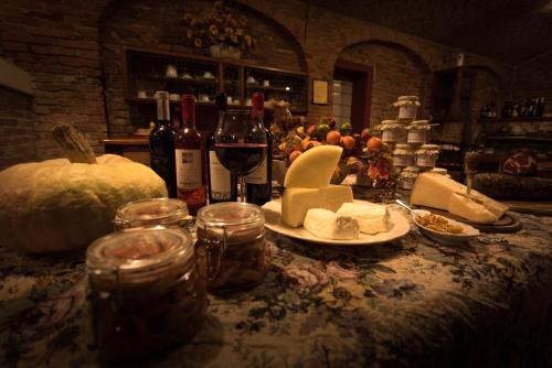 a table with wine glasses and cheese and wine bottles at Agriturismo Albero del Latte in Bagnolo San Vito