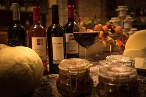 a table with wine bottles and a glass of wine at Agriturismo Albero del Latte in Bagnolo San Vito