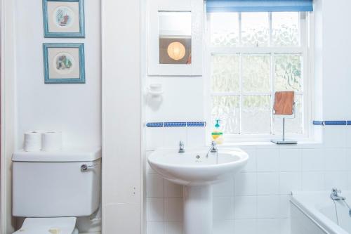 ein Badezimmer mit Waschbecken und Toilette und einem Fenster in der Unterkunft Pilgrims in Haverfordwest