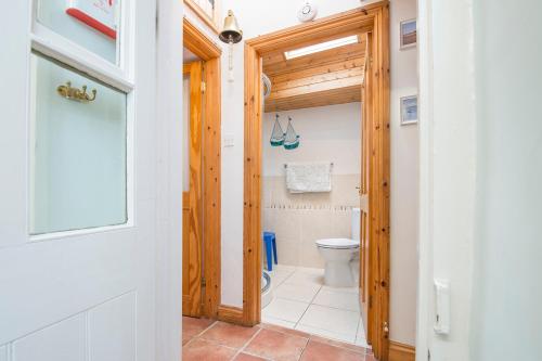 ein Badezimmer mit Toilette und Holztür in der Unterkunft Ivy Cottage in Haverfordwest