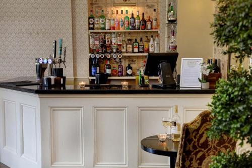 a bar in a restaurant with a counter and a table at Leigh Park Country House Hotel & Vineyard, BW Signature Collection in Bradford on Avon