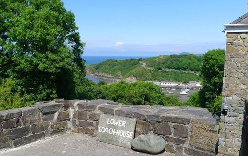 a stone wall with a sign that reads lower opportunities at Lower Coach House in Fishguard