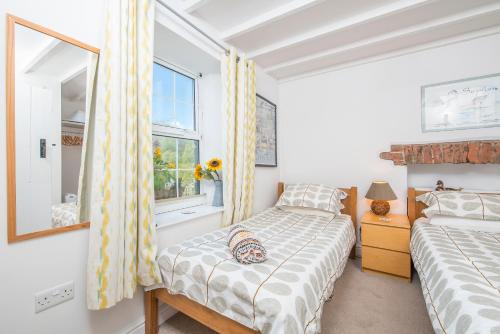 ein Schlafzimmer mit zwei Betten und einem Fenster in der Unterkunft Weavers Cottage in Lampeter-Velfrey