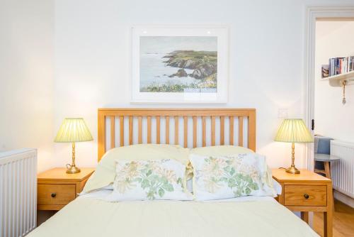 a bedroom with a bed with two night stands and two lamps at Hafod in Tenby