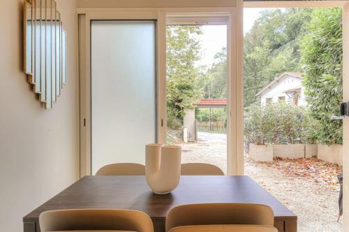une table de salle à manger avec des chaises et une grande fenêtre dans l'établissement Charmant appartement en duplex pour 4, St-Didier, à Saint-Didier-au-Mont-dʼOr