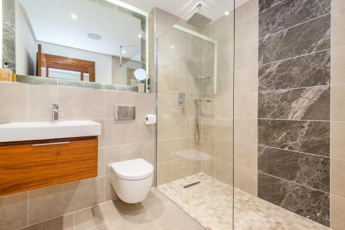 a bathroom with a shower and a toilet and a sink at 16 Waters Edge in Tenby