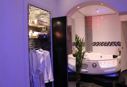 a bathroom with a tub and a large mirror at Le Love Spa in Lyon