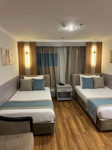 a hotel room with two beds and a couch at MS Chateau Lafayette Nile Cruise - 4 nights from Luxor each Monday and 3 nights from Aswan each Friday in Luxor