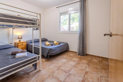 ein Schlafzimmer mit zwei Etagenbetten und einem Fenster in der Unterkunft Villa Luz Lloret Lux with Pool in Lloret de Mar