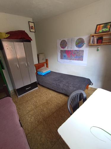 a bedroom with a bed and a cabinet and a table at República Engenho Quarto Triplo II in Ouro Preto