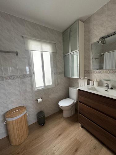 a bathroom with a toilet and a sink and a mirror at PortoHome Ático in Portomarin