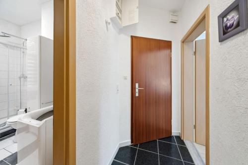 a hallway with a wooden door in a bathroom at Schöne Erdgeschoss-FeWo für 4 Personen in Halberstadt