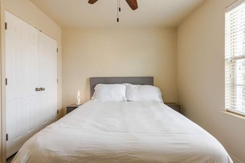 a bedroom with a large bed with white sheets at Stunning 4-Bedroom Spacious 2-Story Home in Buda