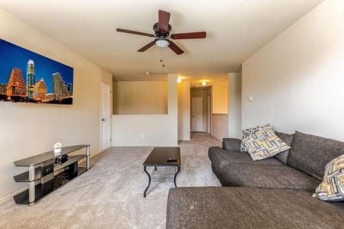 a living room with a couch and a ceiling fan at Stunning 4-Bedroom Spacious 2-Story Home in Buda
