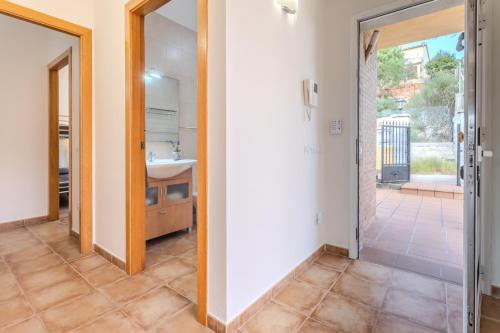 ein Badezimmer mit einem Waschbecken und einer Tür zum Hof in der Unterkunft Villa Luz Lloret Lux with Pool in Lloret de Mar
