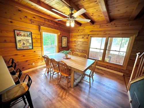 a dining room with a wooden table and chairs at HGTV Log Cabin near Lake Willoughby, Burke, Jaypeak ang Kingdom Trails in Barton