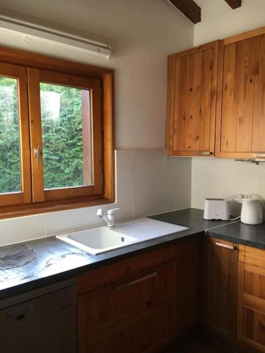 une cuisine avec un évier et une fenêtre dans l'établissement Chalet Mao, à Megève