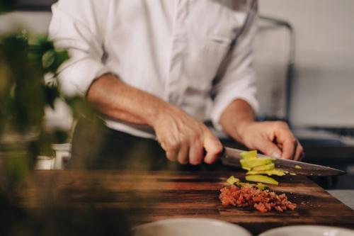 a chef cutting up vegetables on a cutting board at Valsegg Chalets Südtirol - luxury and private hideaway in Valles