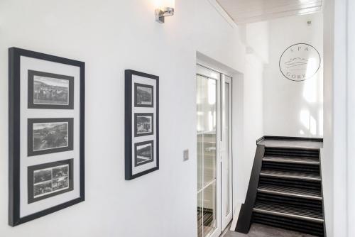 a staircase in a white room with pictures on the wall at Spa Górka in Szklarska Poręba