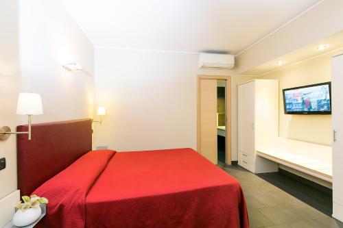 una camera con letto rosso e televisore di Hotel Residenza Gra 21 a Roma