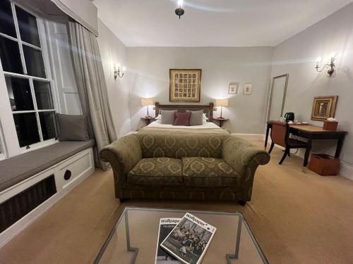 a bedroom with a couch and a bed and a desk at Montigo Resorts, Somerset in Shepton Mallet