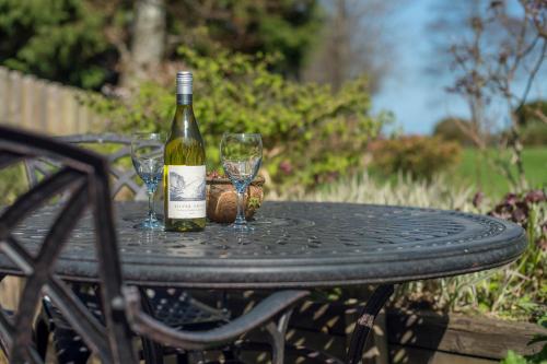 a bottle of wine sitting on a table with two glasses at 3 Tower Hill in Dinas