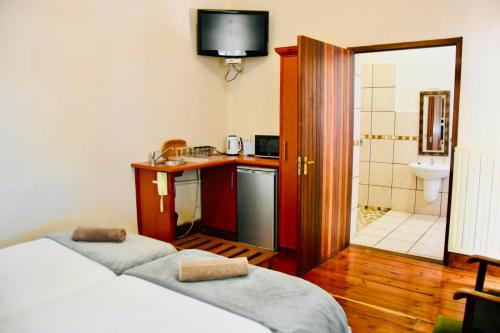 a room with two beds and a bathroom with a sink at Donkin Country House in Beaufort West