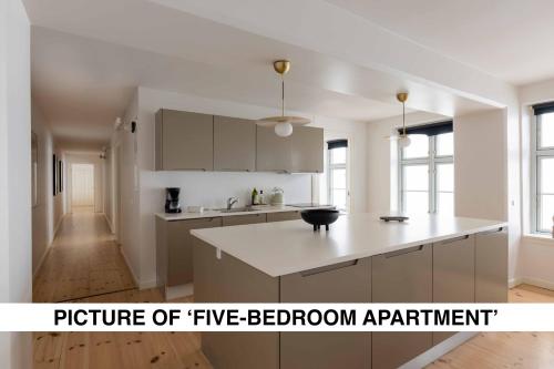 a kitchen with white cabinets and a white counter top at Central City Apartment on Best Location by Round Tower in Copenhagen