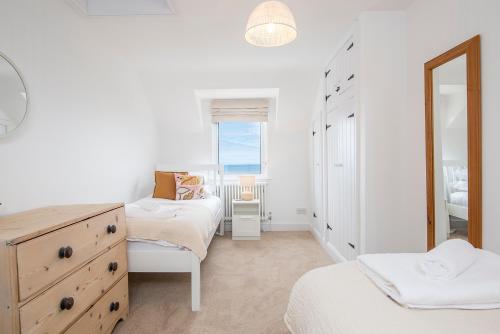 1 dormitorio con 2 camas, tocador y espejo en Ty Perci Penrhiw, en Dinas