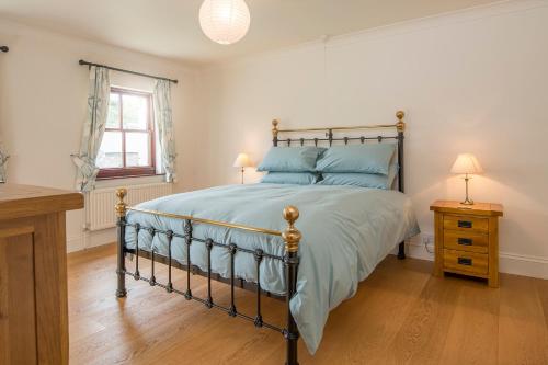 Un dormitorio con una cama y dos lámparas sobre una mesa. en Coastal View, en Haverfordwest