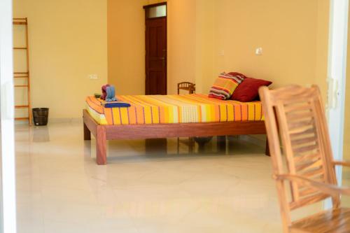 a couch sitting in a room with a chair at Monkey villa in Hikkaduwa
