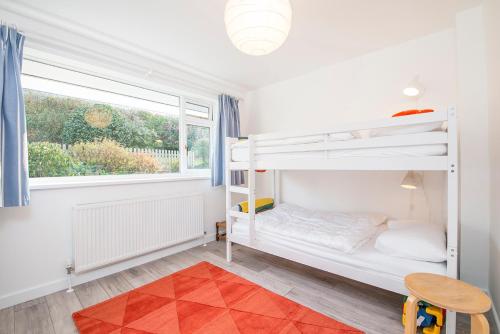 Un dormitorio con dos literas y una ventana. en Awel Y Mor, en Newport