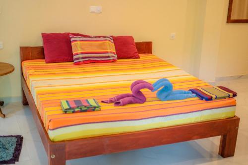 a bed with two stuffed animals sitting on it at Monkey villa in Hikkaduwa