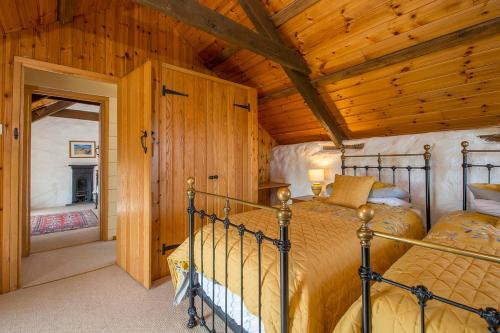 a bedroom with a bed in a room with wooden ceilings at Lower Porthmawr in Haverfordwest