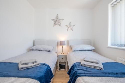 Dos camas individuales en una habitación con ventana. en Sandy-Rise, en Haverfordwest