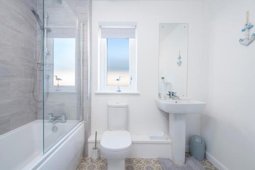 Un baño blanco con inodoro y lavabo. en Sandy-Rise, en Haverfordwest