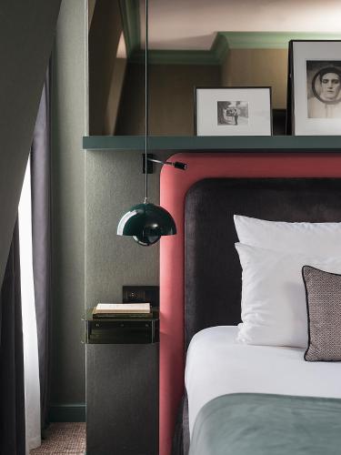 a bedroom with a bed with a black and red headboard at Bob Hotel in Paris