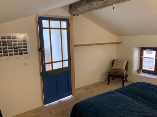 - une chambre avec une porte bleue et une chaise dans l'établissement Authentiek huis op 5 km van Uzes met prachtig uitzicht en terras met jacuzzi, à Serviers-et-Labaume